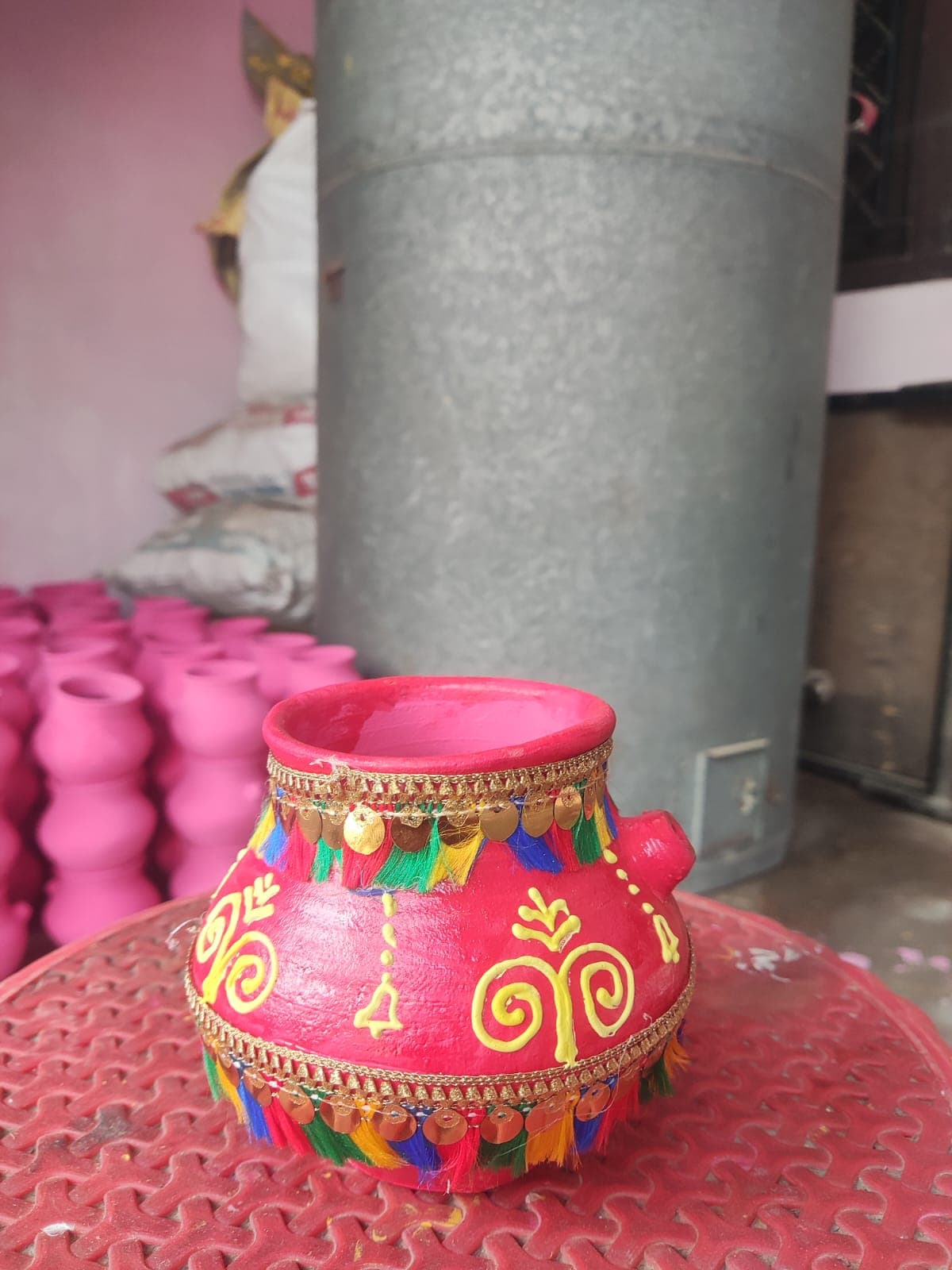 Red decorative clay pot with golden lace